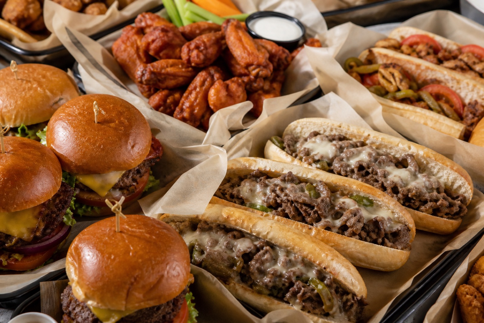 Trays of King's Kitchen-style burgers, cheesesteaks, and wings